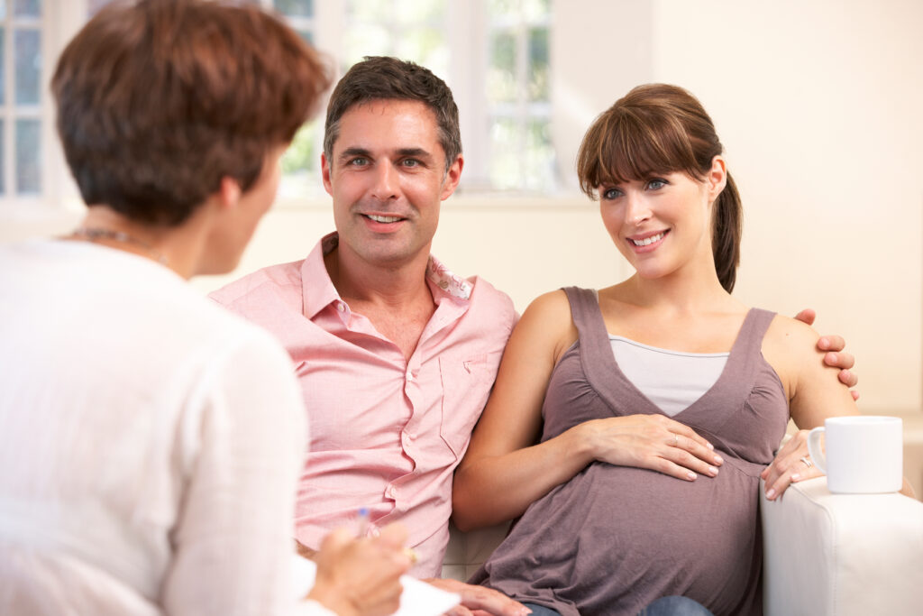 Expectant couple talking to midwife